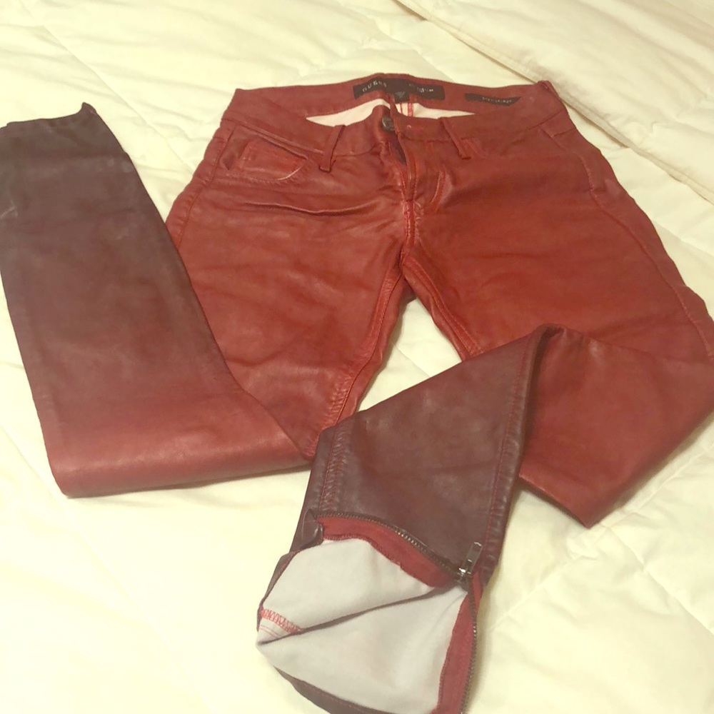 A pair of reddish leathery Guess jeans.